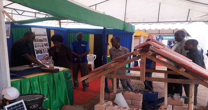Fundi sanifu kutoka NHBRA akitoa maelezo ya upimaji wa udongo unaofaa kwa kutengenezea matofali ya kufungamana kwa Spika Mstaafu Mh.Anne Makinda alipotembelea banda la NHBRA kwenye maonesho ya nanenane 2016 Mkoani Lindi