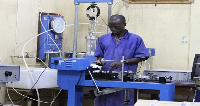 Fundi sanifu akipima uimara wa udongo na uwezo wa kubeba mzigo kwa kutumia mashine ya direct shear katika maabara ya NHBRA