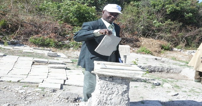 Fundi Sanifu kutoka NHBRA akiangalia kigae cha udongo kilichochomwa katika Kijiji cha Kasanga Wilayani Mufindi wakati alipotembelea Kijiji hicho kufanya utafiti juu ya vifaa vya ujenzi