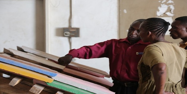 Wananchi waliotembelea ofisi za NHBRA wakipata maelezo kutoka kwa Mtaalam wa Wakala wa Taifa wa Utafiti wa Nyumba Bora na Vifaa vya Ujenzi  kuhusiana na vigae vya kuezekea