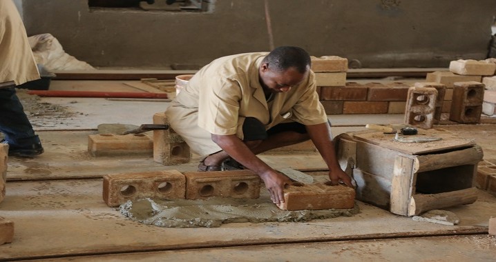 Fundi Sanifu wa NHBRA akiseti tofali kwa ajili ya ujenzi wa kuta ambayo inafanyiwa utafiti