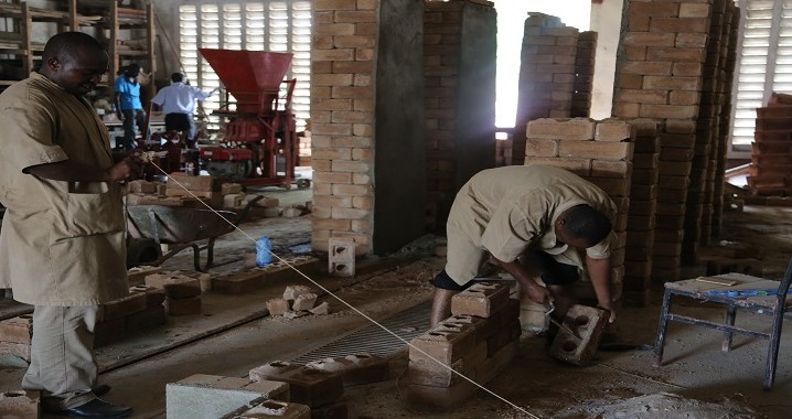 Mafundi Sanifu wa NHBRA wakijenga ukuta kwa ajili ya majaribio ya ujenzi wa plasta kwa kutumia majani ya mpunga